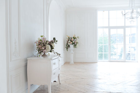 chic white huge spacious hall with a minimum of expensive antique furniture. Baroque interior design...