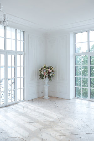 chic white huge spacious hall with a minimum of expensive antique furniture. Baroque interior design with ornament on the walls and parquet on the floor.の写真素材