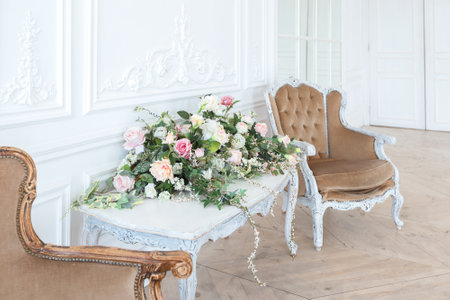 chic white huge spacious hall with a minimum of expensive antique furniture. Baroque interior design...