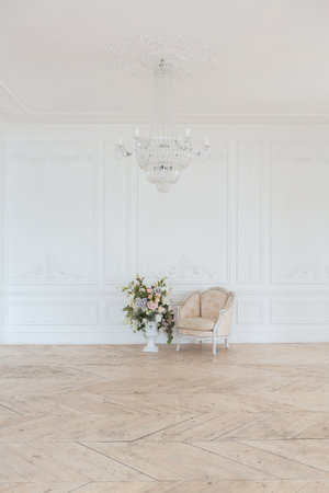 chic white huge spacious hall with a minimum of expensive antique furniture. Baroque interior design with ornament on the walls and parquet on the floor.の写真素材