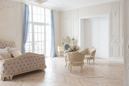 luxurious light interior in the Baroque style. A spacious room with a road chic beautiful furniture, a fireplace and flowers. plant stucco on the walls and light wood parquetの写真素材