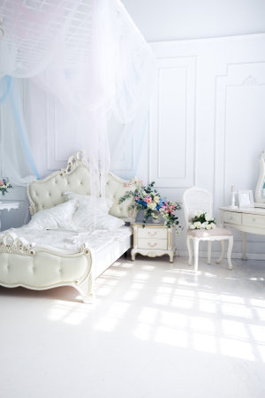 Bright luxury white and blue colored interior living room with flowers in vases. the walls are decorated with baroque ornamentsの写真素材