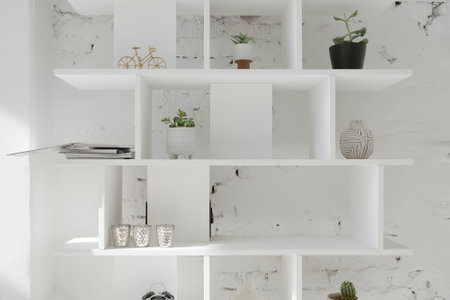 Spacious stylish modern trendy loft apartment in white and light colors. a large room full of sunlight. brick wall, wood floor, shelving, pallet bed and huge window. everything is white with gray tints.の写真素材