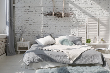 Spacious stylish modern trendy loft apartment in white and light colors. a large room full of sunlight. brick wall, wood floor, shelving, pallet bed and huge window. everything is white with gray tints.の写真素材