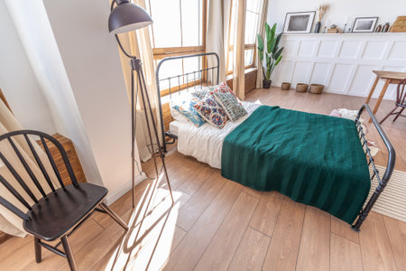 Vintage studio apartment interior in light colors in old style. huge room with large windows with a living room area and a bedroom area. direct sunlight inside.の写真素材