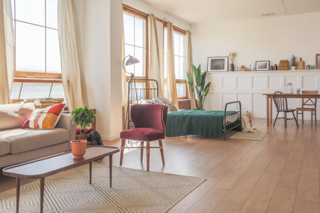 Vintage studio apartment interior in light colors in old style. huge room with large windows with a living room area and a bedroom area. direct sunlight inside.の写真素材