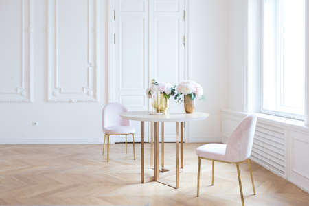 chic spacious light room in an old mansion in the classical style of the 19th century with a high ceiling decorated with stucco on white wallsの写真素材