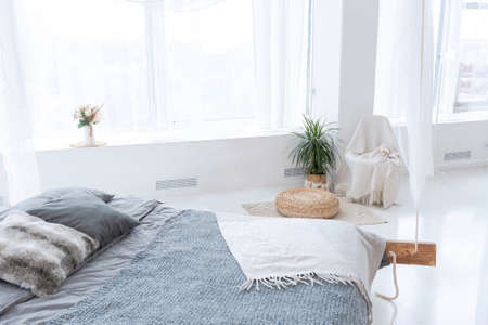 large very bright spacious stylish open plan Bali style apartment with hanging bed and panoramic windows. white floor and walls, simple wooden furniture.の写真素材