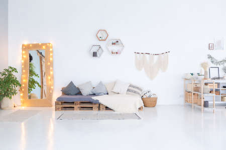 large very bright spacious stylish open plan Bali style apartment with hanging bed and panoramic windows. white floor and walls, simple wooden furniture.の写真素材