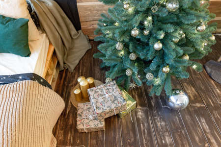 On the eve of the holiday, the interior of the country house is decorated with a New Year tree. large spacious light room decorated with wood with simple wood furnitureの写真素材