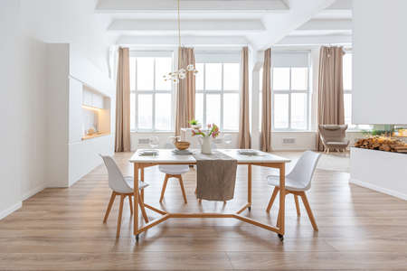 interior design spacious bright studio apartment in Scandinavian style and warm pastel white and beige colors. trendy furniture in the living area and modern details in the kitchen area.の写真素材
