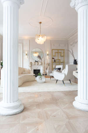 rich luxurious interior of a cozy room with modern stylish furniture nd grand piano, decorated with baroque columns and stucco on the wallsの写真素材