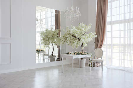 luxurious bright spacious guest room with beautiful chic furniture a huge floor-to-ceiling window in...