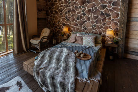 dark cozy interior of big country wooden house, wooden furniture and animal furs. huge panoramic window and very high ceiling.の写真素材