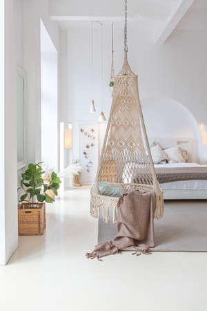 Fashionable modern interior of a light studio apartment with wooden columns in the loft style, decorated with brick, marble and wood with stylish furniture and white wallsの写真素材