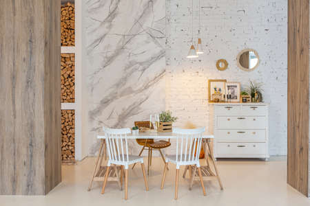 Fashionable modern interior of a light studio apartment with wooden columns in the loft style,...
