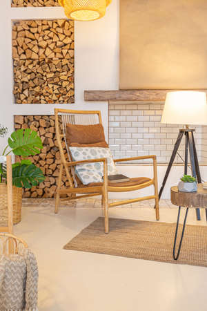 Fashionable modern interior of a light studio apartment with wooden columns in the loft style, decorated with brick, marble and wood with stylish furniture and white wallsの写真素材