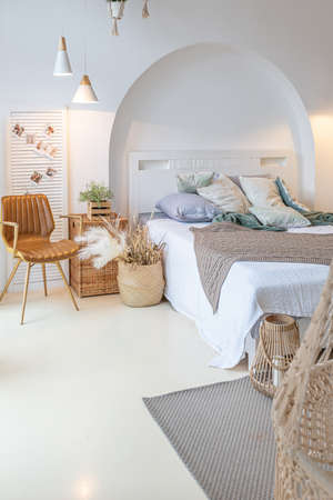 Fashionable modern interior of a light studio apartment with wooden columns in the loft style, decorated with brick, marble and wood with stylish furniture and white wallsの写真素材