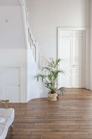 modern interior of a bright room in a two-storey apartment with decorative items in bali style with a balcony. white walls, wood floors and vintage furnitureの写真素材