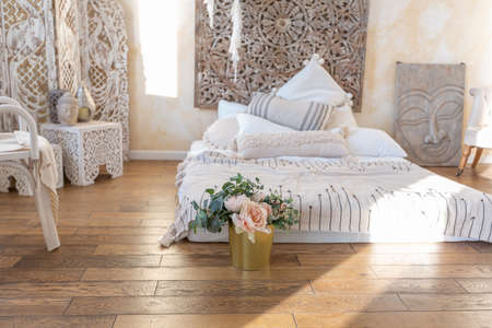 modern interior of a bright room in a two-storey apartment with decorative items in bali style with a balcony. white walls, wood floors and vintage furnitureの写真素材