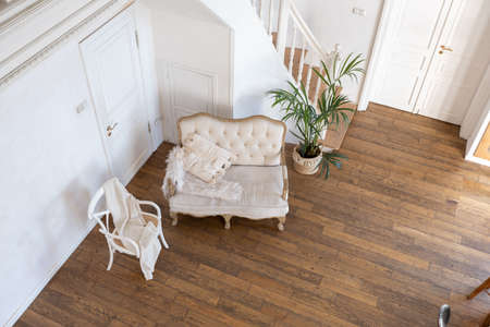 modern interior of a bright room in a two-storey apartment with decorative items in bali style with a balcony. white walls, wood floors and vintage furnitureの写真素材