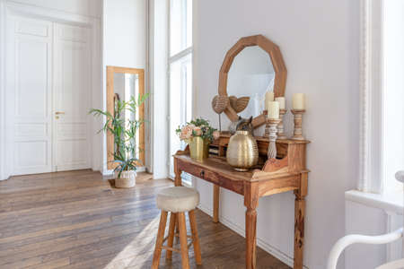modern interior of a bright room in a two-storey apartment with decorative items in bali style with a balcony. white walls, wood floors and vintage furnitureの写真素材