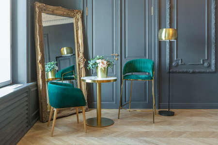 chic interior of the room in the Renaissance style of the 19th century with modern luxury furniture. walls of noble dark color are decorated with stucco and gilded frames, wooden parquet.の写真素材