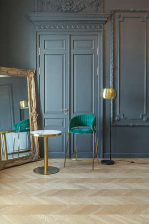 chic interior of the room in the Renaissance style of the 19th century with modern luxury furniture. walls of noble dark color are decorated with stucco and gilded frames, wooden parquet.の写真素材