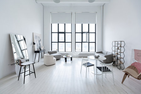 modern minimalistic interior design of light bright monochrome room with black and white furniture, clean white walls and huge windowsの写真素材