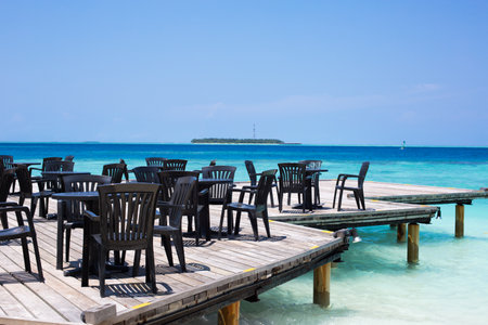 Tables and chairs on the wooden pier in tropical Maldives islandの写真素材