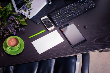 Office desk table with coffee cup, smartphone and other items. View from aboveの写真素材