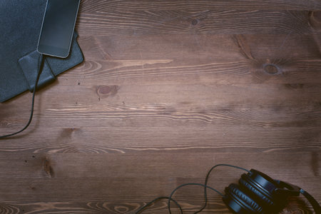 Top view of a wooden desk with laptop, headphones and smartphone.の写真素材
