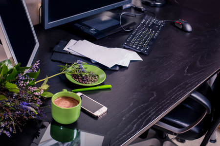 Working place in a modern office. Workplace with computer, cup of coffee and flowers.の写真素材