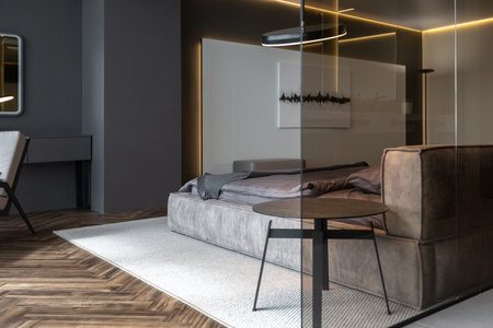 cool expensive interior design of room in prestigious luxury hotel with dark tones with modern LED lighting and stylish furniture. the area with a sink is separated by dark glass from the bedroomの写真素材