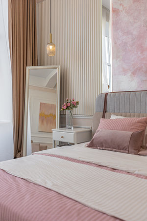 a close view of the bedroom in a modern cozy soft interior in warm delicate pastel pink and beige colorsの写真素材