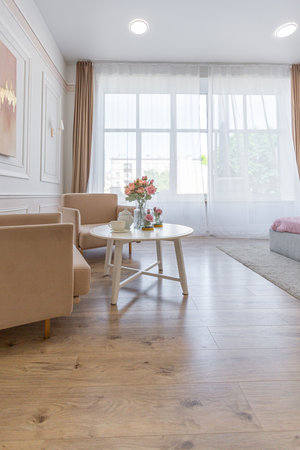 a close view of a tea table with two stylish armchairs in a modern cozy soft interior in warm...