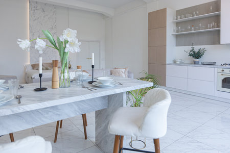 minimalistic light elegant luxury design of a modern spacious studio apartment with kitchen area,...
