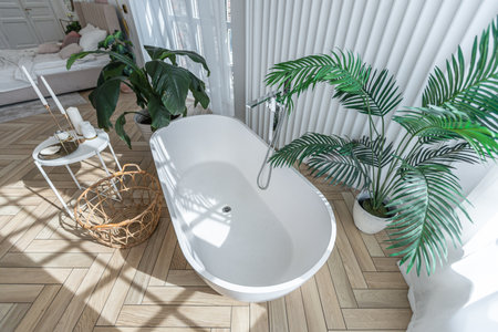 free-standing stylish bath in a spacious open-plan apartment with a stylish modern bright design on...