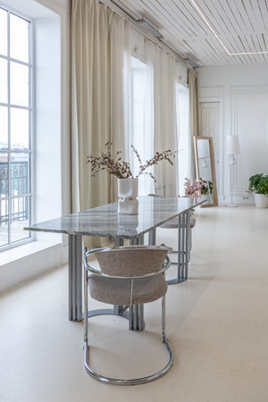 interior of a bright living room in a luxurious baroque style with white walls decorated with...