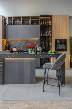 wood decorated dark kitchen area with coocking island in huge modern spacious apartment with high...