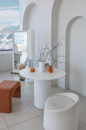modern pure white interior design of a spacious sitting room with soft stylish furniture. Large window frame creating a serene atmosphere during daylight.の写真素材