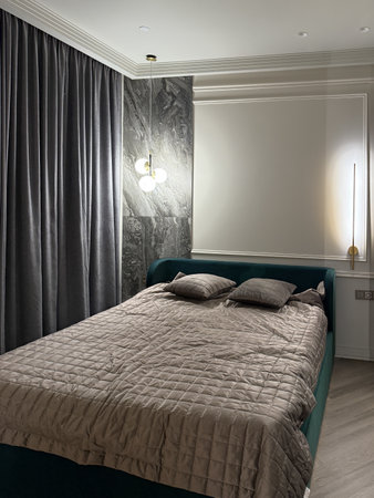 This cozy bedroom features a plush bed adorned with soft pillows, complemented by a sleek, modern closet illuminated from within, enhancing the room's ambiance and elegance.の写真素材