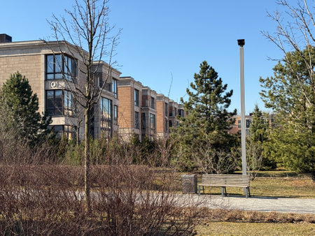 modern, multi-story residential buildings with large windows and beige stone facades. The architecture is elegant and contemporary. The weather is clear and sunny, with a bright blue skyの写真素材