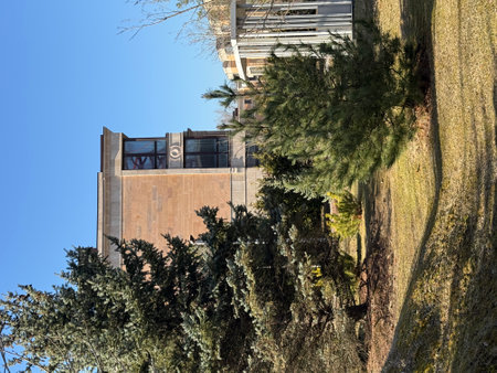 modern, multi-story residential buildings with large windows and beige stone facades. The architecture is elegant and contemporary. The weather is clear and sunny, with a bright blue skyの写真素材