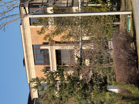 modern, multi-story residential buildings with large windows and beige stone facades. The architecture is elegant and contemporary. The weather is clear and sunny, with a bright blue skyの写真素材