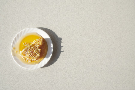 Honey comb on a white saucer on the  white background