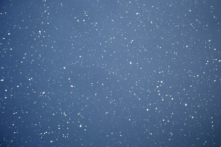 snowflakes on dark skyの写真素材