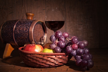 Glass of red wine and barrel on rustic wood tabel.の写真素材