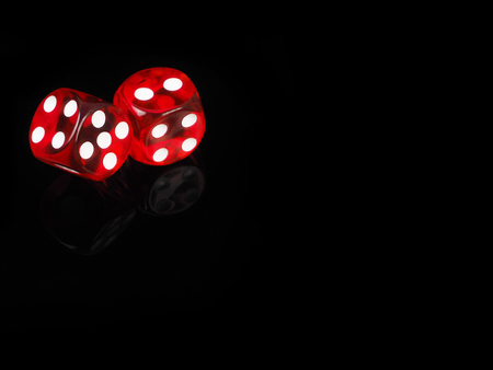 Two red casino dices with  reflection . black background.の写真素材