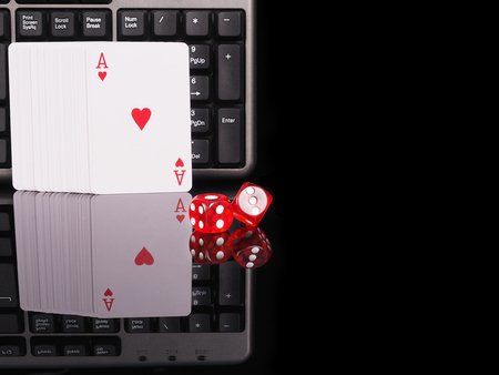 Cards, dice beside the keyboard. online card games concept .の写真素材